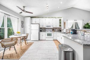 een keuken met witte apparatuur en een tafel en stoelen bij Cozy Boho Kildaire Farms Home- near Downtown in Cary