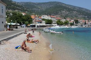 a group of people on a beach near the water at Apartments by the sea Bol, Brac - 13539 in Bol