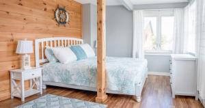 a bedroom with a bed and a wooden wall at Main Street Downtown Apartments in Bar Harbor