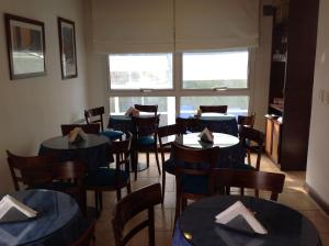 a dining room with tables and chairs and a window at Olas Apart High Comfort in Villa Gesell