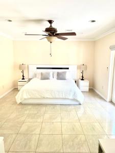 een slaapkamer met een bed en een plafondventilator bij Victoria Park Home, Private Pool 2miles from Beach in Fort Lauderdale