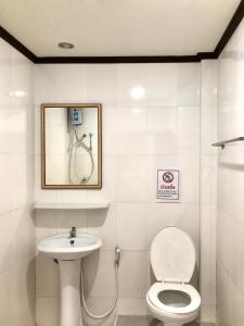 La salle de bains est pourvue de toilettes et d'un lavabo. dans l'établissement Visanuinn Hotel, à Nakhon Sawan
