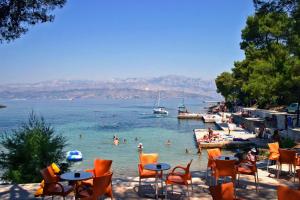 un groupe de personnes dans l'eau sur une plage dans l'établissement Family friendly house with a swimming pool Skrip, Brac - 15297, à Supetar