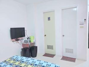 a room with two doors and a tv and a bed at N&J Lopez Lodging House in Manila
