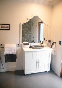 een badkamer met een wastafel en een spiegel bij Dorrigo Bush Pepper Retreat in Deer Vale