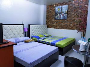 a room with two beds and a table and a desk at N&J Lopez Lodging House in Manila
