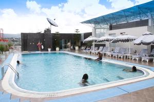a group of people swimming in a swimming pool at Inter Luxury Hotel in Addis Ababa