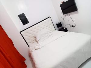 a white bedroom with a bed and a tv at N&J Lopez Lodging House in Manila +18 photos