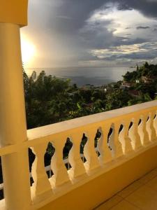 a white railing with a view of the ocean at Modern Air Conditioned Home For Family & Adventure in Loubiere