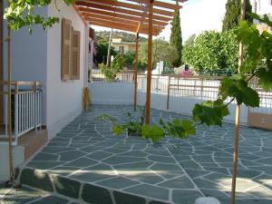 a stone patio with a pergola on a house at George's Apartment in Agia Marina Aegina