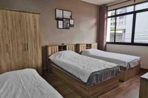 um quarto com 2 camas e uma janela em 8FINITE House em Bang Su