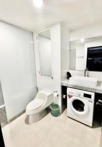 a white bathroom with a toilet and a sink at Patong Tower Amazing Sea View 12 by PHR in Patong Beach
