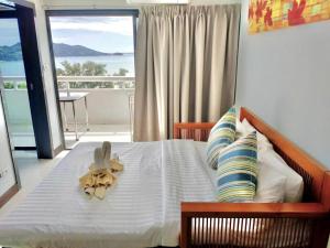 a bedroom with a bed with a stuffed animal on it at Patong Tower Amazing Sea View 12 by PHR in Patong Beach