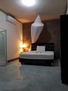 1 dormitorio con 1 cama con mosquitera encima en BANYU URIP ROOMS, en Kuta Lombok