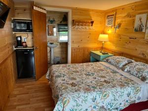 1 dormitorio con 1 cama en una cabaña de madera en The Coastal Cabins in New Brunswick, en Cape Tormentine