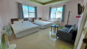 1 dormitorio con 2 camas, sofá y silla en 尖山沐氧 Jianshan Bathe Oxygen, en Kenting