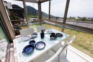 una mesa blanca con platos y utensilios. en しっぽの森リゾート淡路島〜サウナ&スタジオ〜 en Awaji