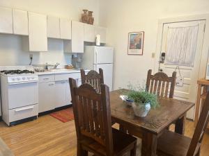 a kitchen with a wooden table with chairs and a kitchen with white appliances at Canyon Rose Suites in Bisbee