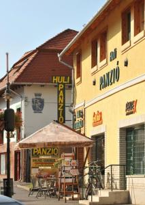 un restaurant avec des tables et des chaises en face d'un bâtiment dans l'établissement Huli Panzio, à Tokaj