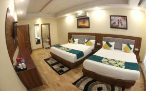 a hotel room with two beds and a mirror at The Royal Bhumesh in Katra +25 photos