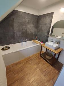 La salle de bains est pourvue d'un lavabo et d'une baignoire. dans l'établissement Villa Viveye, à Ferrières