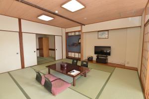 sala de estar con mesa y TV en Yataro en Nagasaki