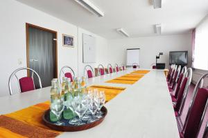 ein großer Konferenzraum mit einem langen Tisch mit Weingläsern in der Unterkunft Gasthaus Zum Rethberg in Lübstorf