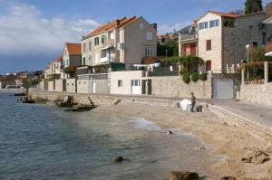 eine Gruppe von Gebäuden an einem Strand neben dem Wasser in der Unterkunft Apartments by the sea Bol, Brac - 4657 in Bol