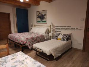 a bedroom with two beds and a chair and a table at Casa Montefiore 13 LT nella tranquilla campagna Marchigiana in Ancona