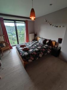 a bedroom with a bed and a large window at Villa Viveye in Ferrières