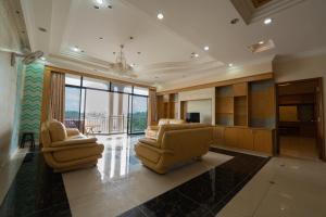 uma grande sala de estar com duas cadeiras e uma televisão em MK Homestay Wakaf Che Yeh with bathtub - Max 14 Pax em Kota Bharu