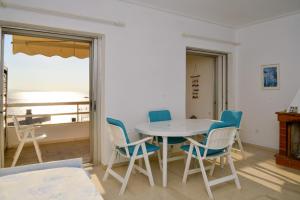 a table and chairs in a room with a view of the ocean at Anavissos Panoramic sea view apt with shared pool in Anavyssos