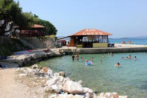 un gruppo di persone in acqua in spiaggia di Apartments by the sea Tkon, Pasman - 16589 a Tkon (Tuconio)