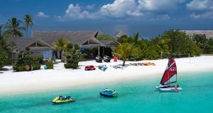 twee boten in het water voor een strand bij Cora Cora Maldives - Premium All-Inclusive Resort in Raa Atol