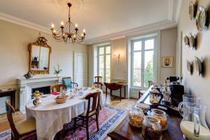 a dining room with a table and a chandelier at Maison de la Garenne & Spa in Vannes