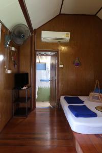 ein Schlafzimmer mit einem Bett und einem TV sowie ein Zimmer mit einer Tür in der Unterkunft The Mermaid House in Ko Kood