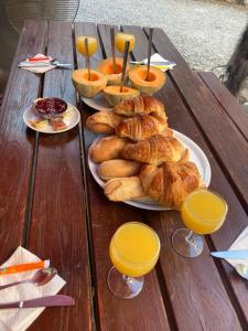 a table with plates of croissants and glasses of orange juice at Chambres d hotes THE RESID in Pérouges