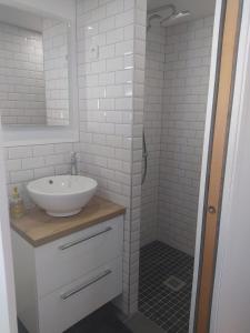 a white bathroom with a sink and a shower at Maisonnette de bord de mer in Étables-sur-Mer