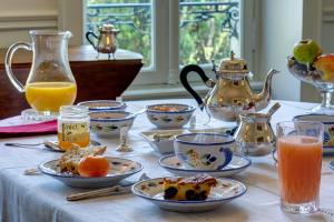 einen Tisch mit Teller mit Speisen und Krugen Orangensaft in der Unterkunft Maison de la Garenne & Spa in Vannes