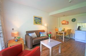 ein Wohnzimmer mit einem Sofa und einem Tisch in der Unterkunft Appartementen Bos en Duin Texel in Den Hoorn