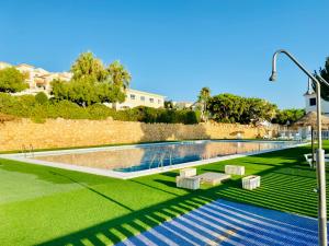 a swimming pool with two chairs and a wall at La Suite Del Mar in Gran Alacant +47 photos
