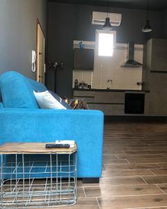 a living room with a blue couch and a kitchen at Casa Renata in Foggia