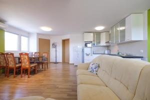 a living room and kitchen with a couch and a table at ITSOFT smart apartment in Komenda