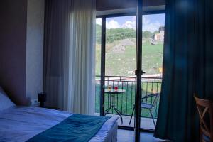 Una cama o camas en una habitación de Hotel GENI Kazbegi