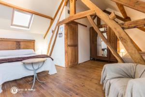 a bedroom with two beds in a attic at Ferme Cacheterie, boutique terroir in Fleury-la-Forêt