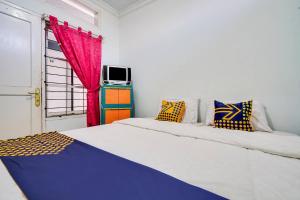 En eller flere senge i et værelse på SPOT ON 91386 De Jawara Homestay Syariah