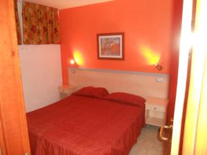 a red bedroom with a red bed and two tables at Apartamentos Green Park in Playa del Ingles