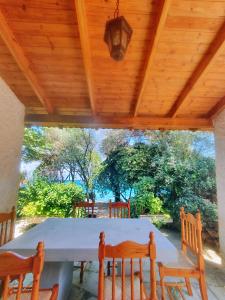 a table and chairs under a wooden ceiling at Villa Al-ari in Diakopto