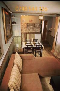 a living room with a couch and a dining room at Vintage Apartment - Ultracentral, 2 dormitoare in Sighişoara