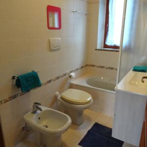 La salle de bains est pourvue de toilettes, d'un lavabo et d'une baignoire. dans l'établissement Appartamento BLU - Colori del Lago D'Orta - NUOVA STRUTTURA A OMEGNA, à Omegna